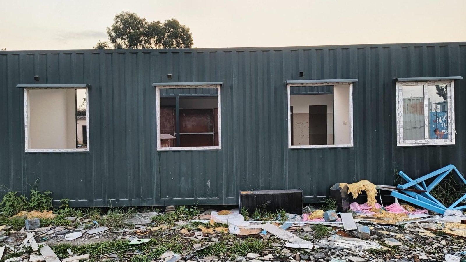 Two white and blue portable cabins on a construction site.